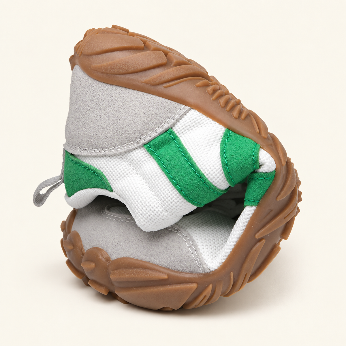 Carrera Urban™, zapatilla blanca y verde doblada mostrando la flexibilidad sobre fondo crema.