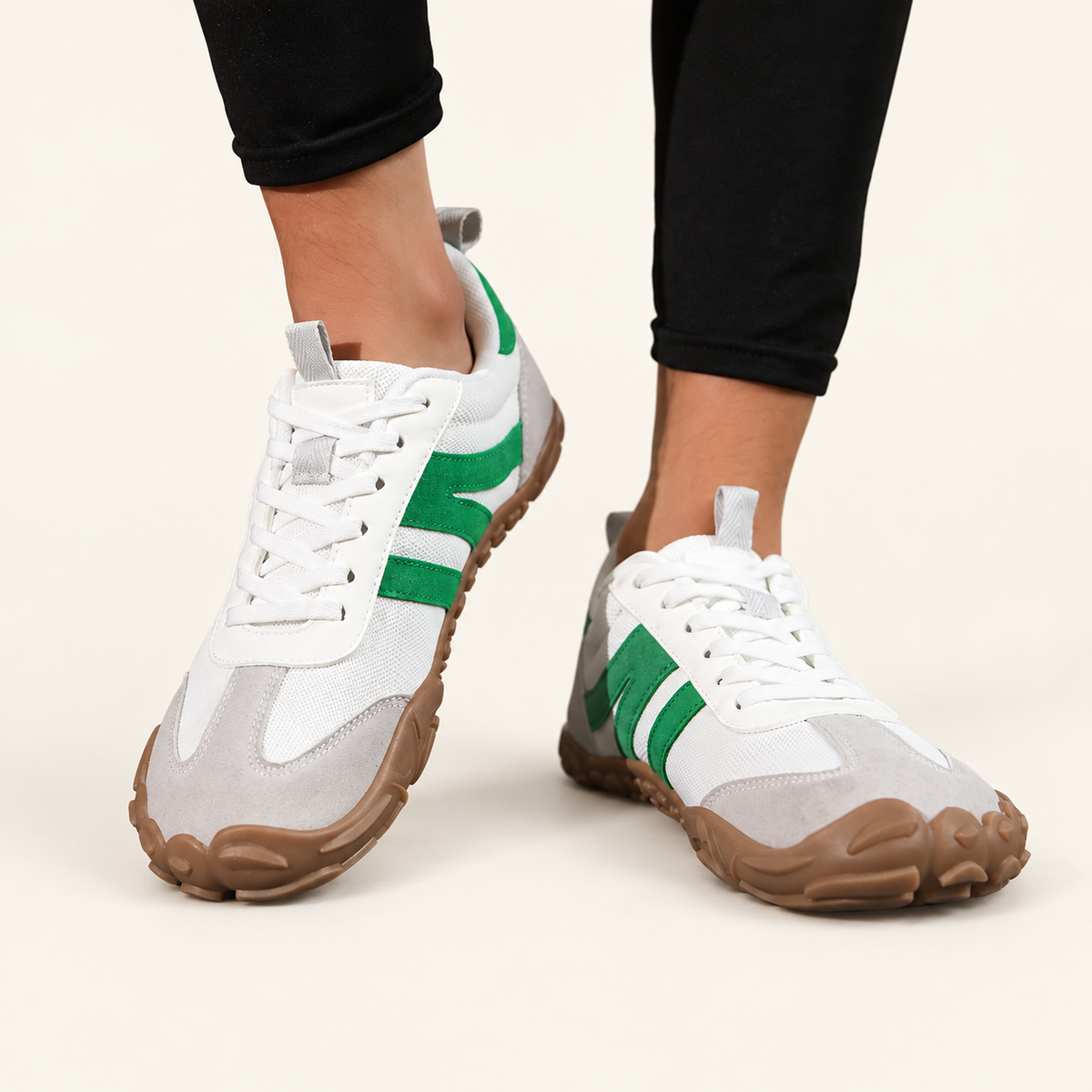 Carrera Urban™, zapatillas blancas y verdes puestas, vistas de frente sobre fondo crema.